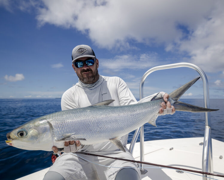 Guest on Alphonse Island holding milkfish which was caught on fly.